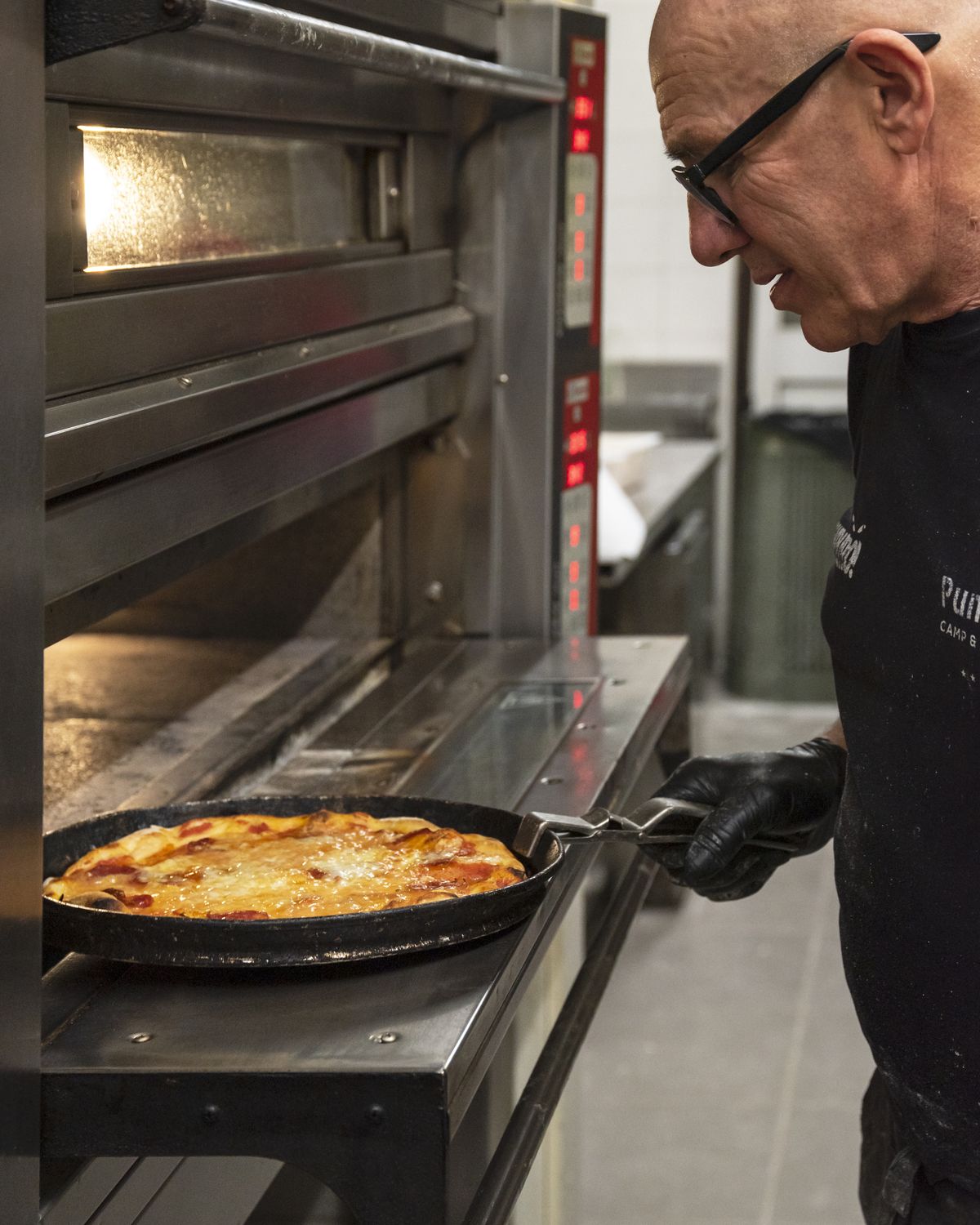 Il pizzaiolo sforna una pizza in teglia