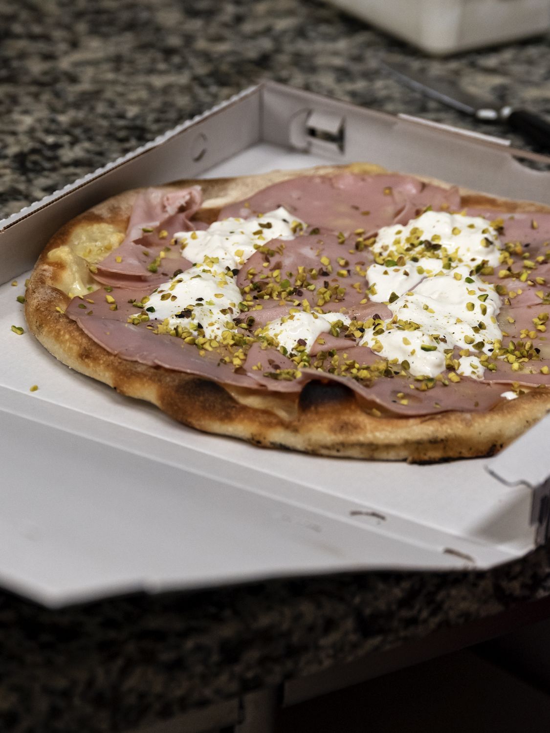 La Romagnola con burrata, mortadella e pistacchio nel cartone da asporto